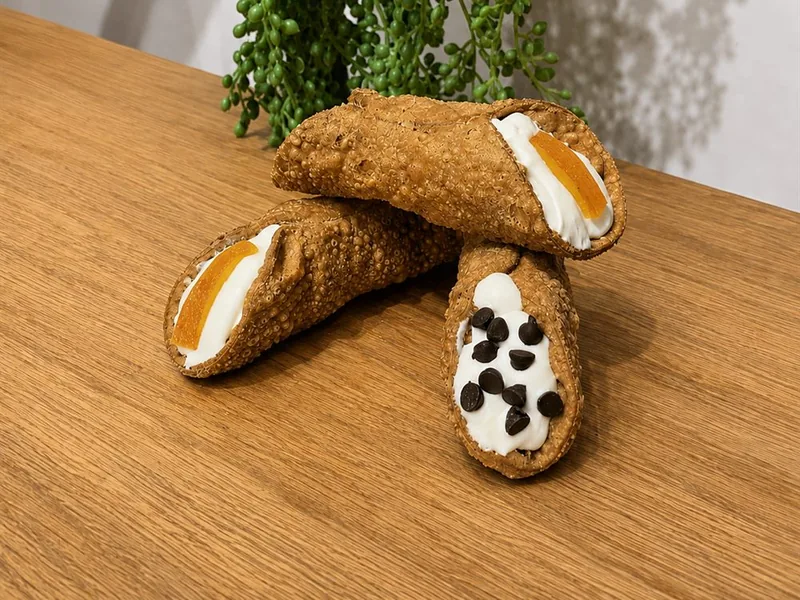 Cannoli della fattoria con crema di ricotta, arancia candita e gocce di cioccolato