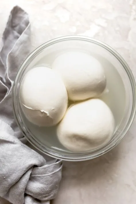 Tre mozzarelle fiordilatte in una ciotola di vetro con il loro liquido di conservazione