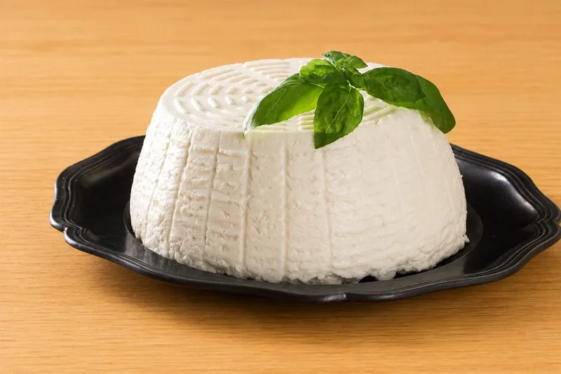 Ricotta di fattoria con foglie di basilico