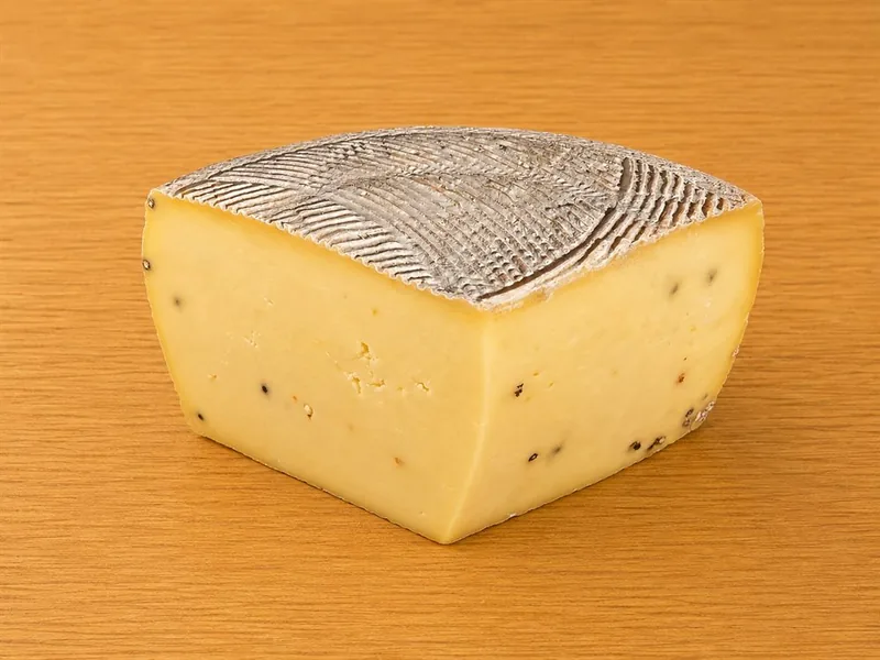 Formaggio allo zafferano e pepe nero, punta tagliata